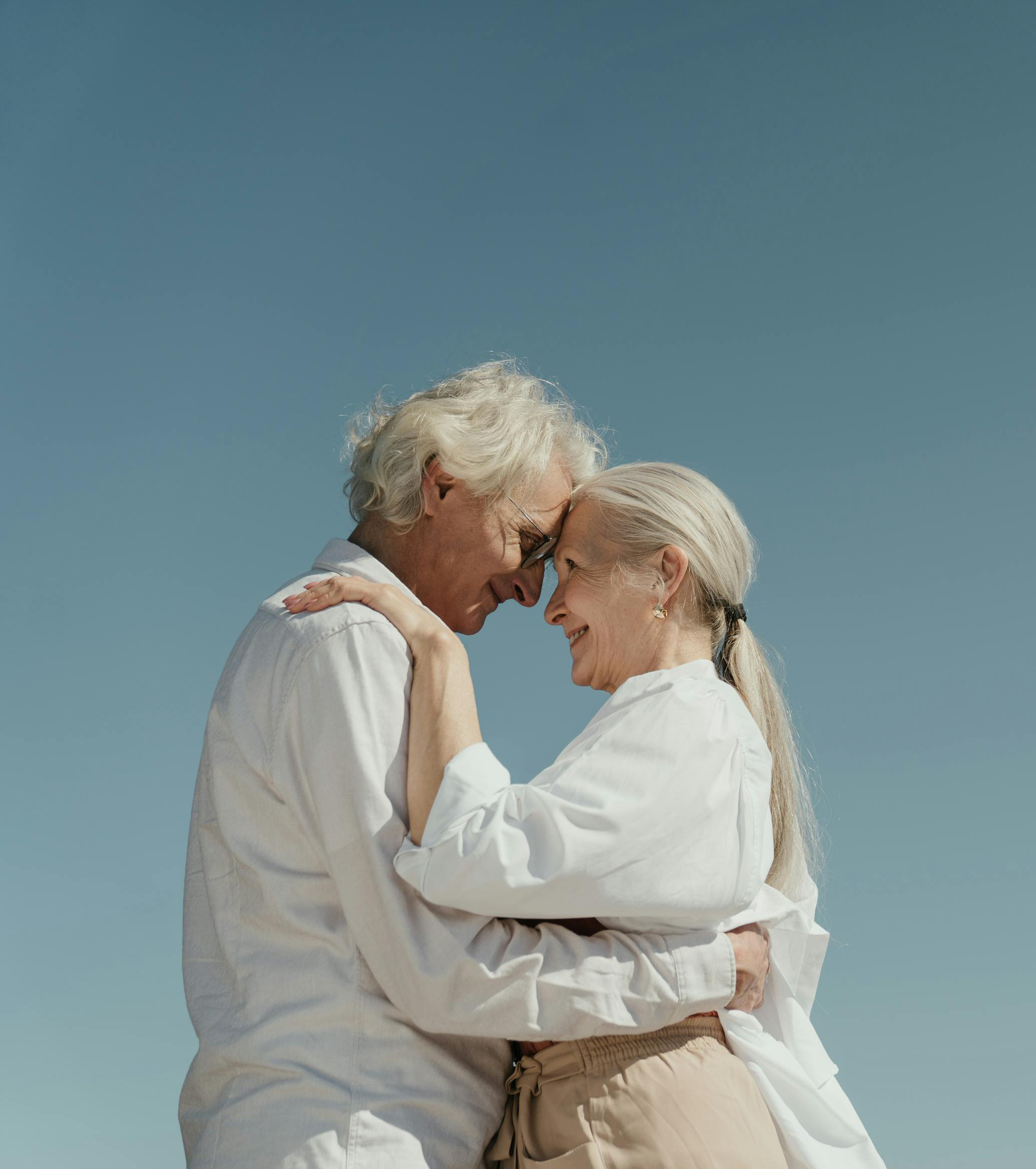 Casal de idosos felizes e abraçados, representando os cuidados prestados pela Avós em Família